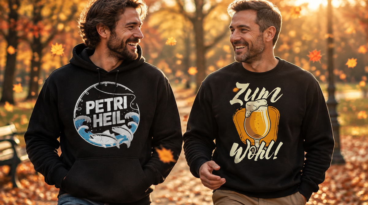 Herbstkollektion – zwei Männer in Petri Heil Hoodie und Zum Wohl Sweatshirt im Herbstpark